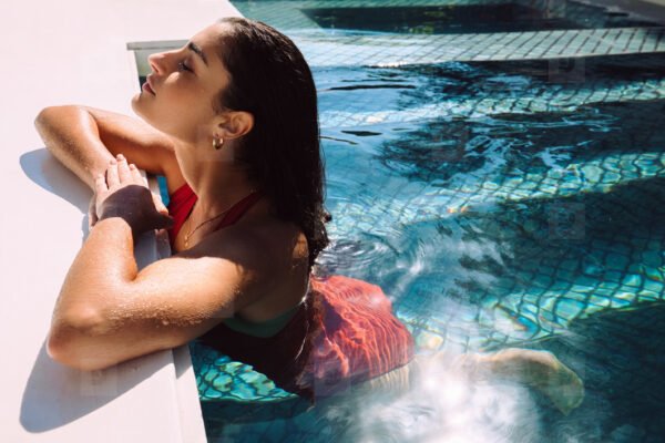 Femme accoudée au bord d'une piscine
